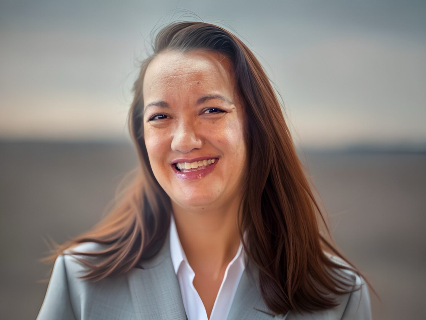 A woman in grey jacket smiling for the camera.